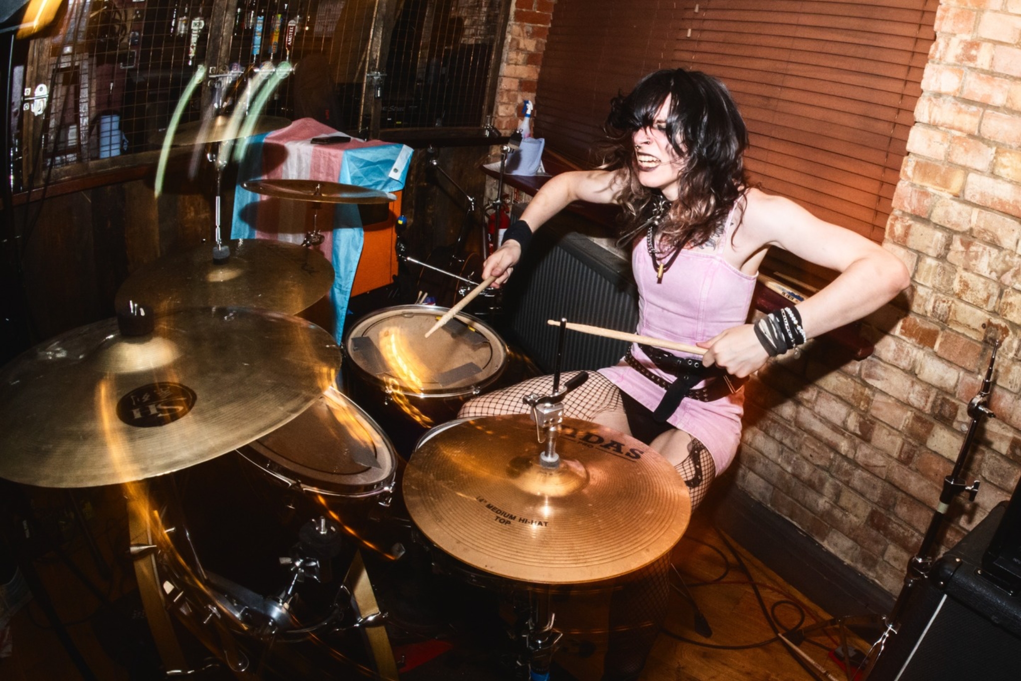Photograph of a drummer aggressively playing a drumkit.